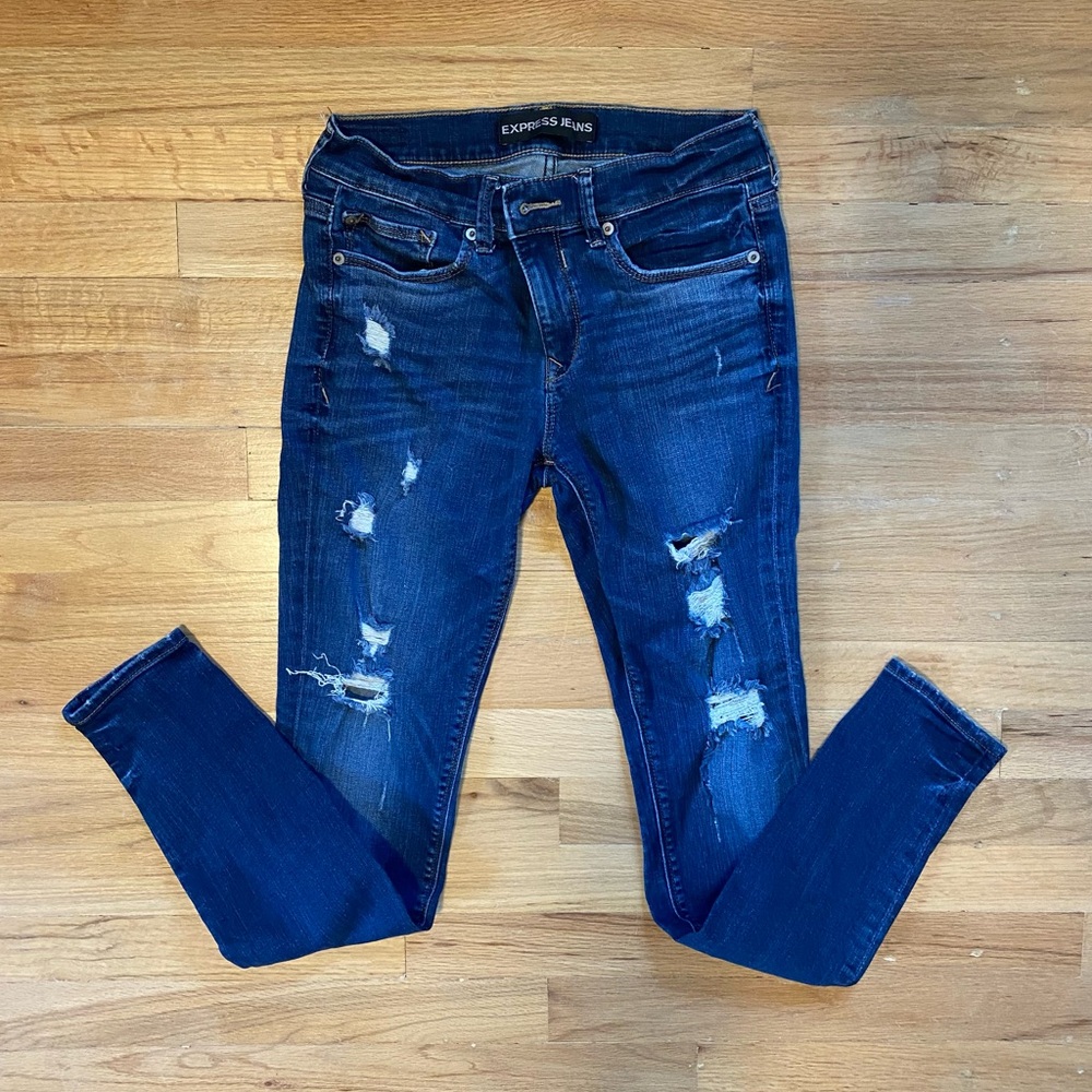 Express women’s medium wash distressed mid-rise legging jeans.